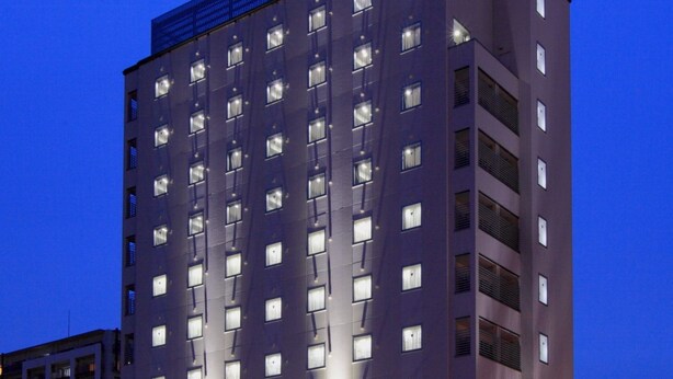 Ein Hotel mit modernem Design, mehreren Etagen und einer auffälligen Schilderung im oberen Bereich.