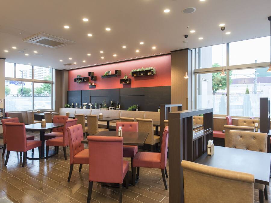 A restaurant with booths and tables, a counter, and a view of the street.