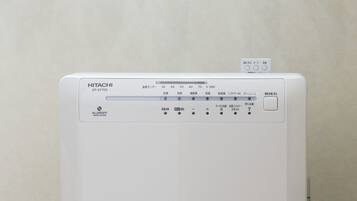 A white HITACHI EP-EV705 refrigerator with a control panel displaying temperature settings and a power button.