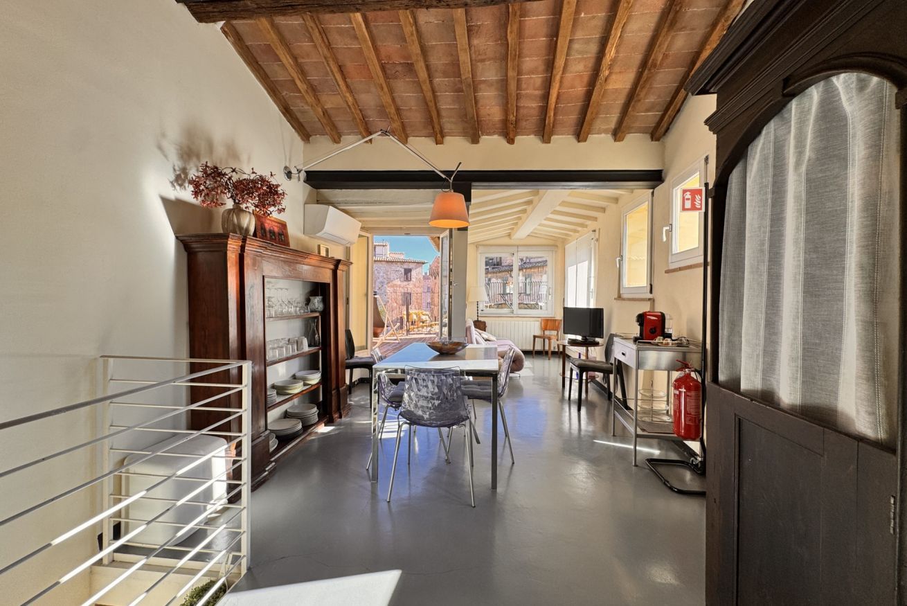 A narrow hallway with a dining area, a fireplace, and a view to the outside.