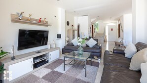 Een moderne woonkamer met een flatscreen televisie, een bank, een salontafel en decoratieve objecten.