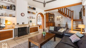 A cozy living room with a fireplace, a sofa, a coffee table, and a bookshelf. - Villa SANDRO by Abahana Villas (Benissa)