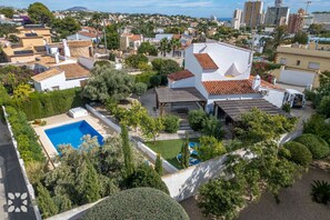 Un quartier résidentiel doté d’une piscine, de maisons blanches et d’une végétation variée.
