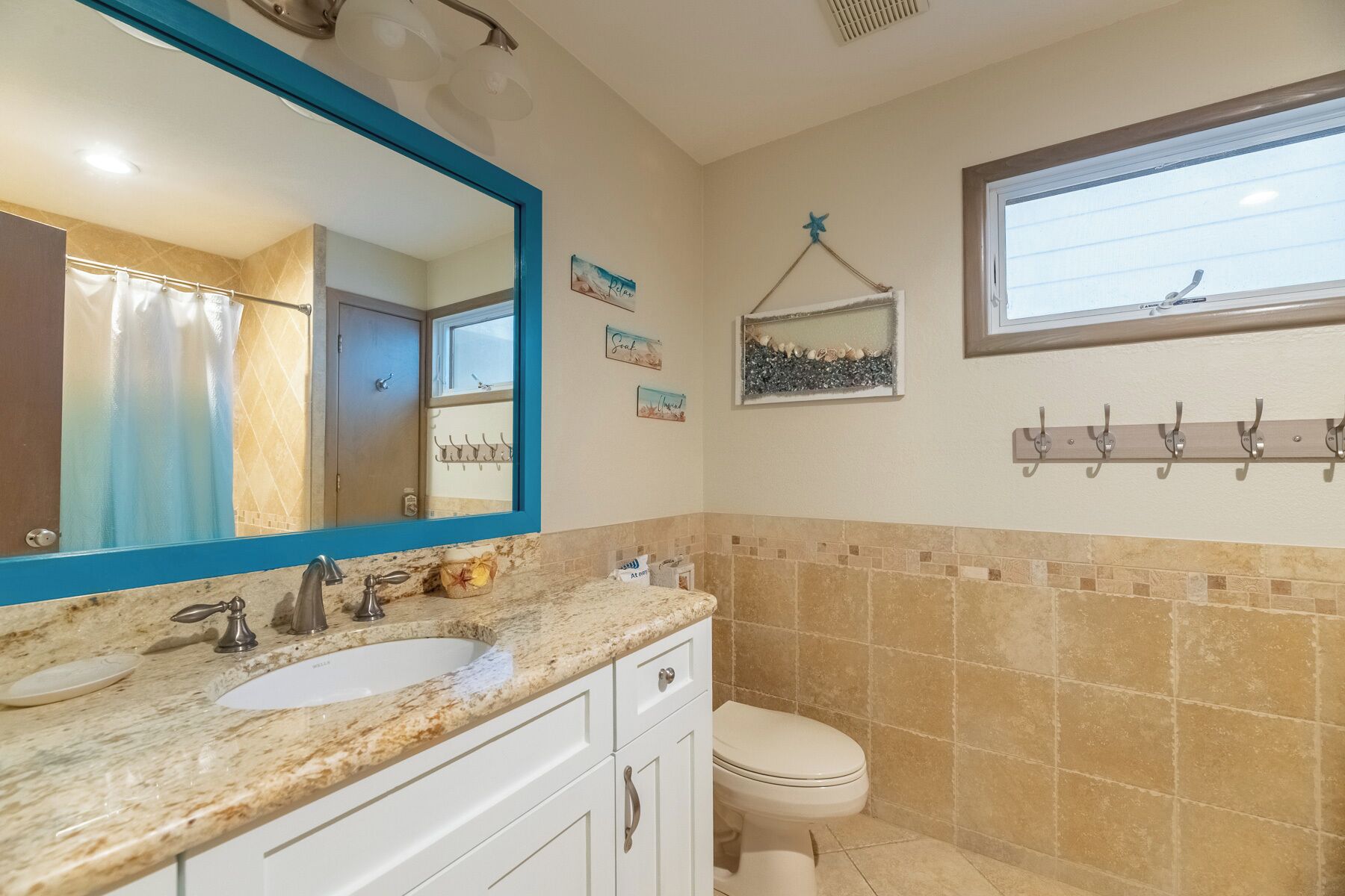 Un baño con lavamanos, espejo e inodoro.