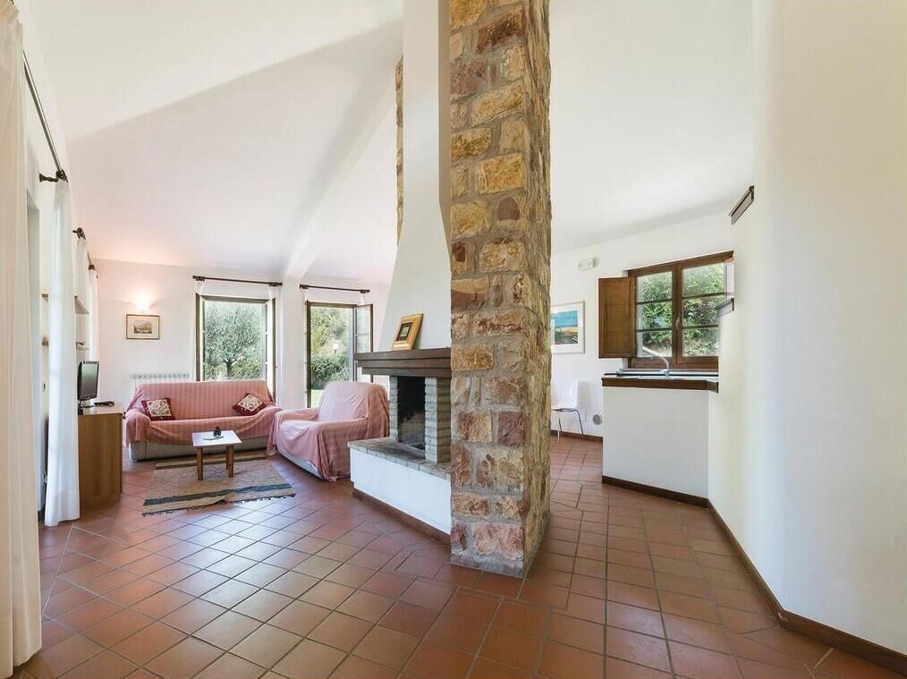 A spacious living area with a stone fireplace, a sofa, and a television.