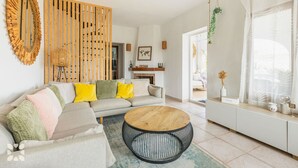 Uma sala de estar moderna com um sofá, uma mesa de centro redonda e um painel de madeira.