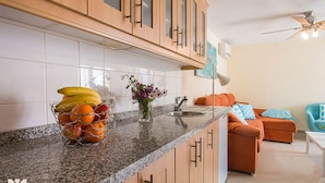 A kitchen with granite countertops, a fruit basket, and a vase of flowers. - Villa LUNA FELIZ by Abahana Villas (Calpe)