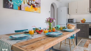 A dining area with a wooden table, blue plates, and a fruit basket. - Villa LUNA FELIZ by Abahana Villas (Calpe)