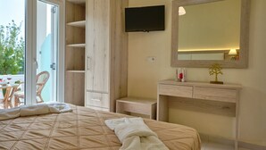 A bedroom with a bed, a wooden wardrobe, a TV, a mirror, and a small table with a lamp. - Katoi studio 3 Agios Georgios Pagoi (Corfu)