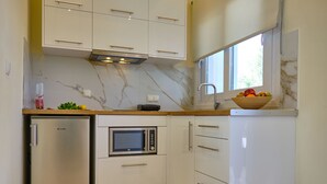 A compact kitchen with a built-in microwave, a refrigerator, and a sink. - Katoi studio 3 Agios Georgios Pagoi (Corfu)