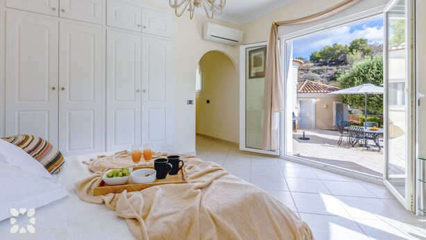 Ein Schlafzimmer mit Bett, Frühstückswagen und Blick auf die Terrass.