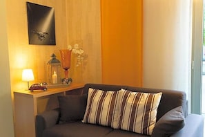 A modern living room with a sofa, a lamp, a decorative vase, and a framed picture on the wall. - Hotel Alter Zoll (Kleinblittersdorf)