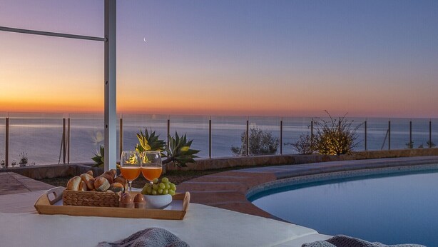A poolside setting with a sunset view, a tray of food and drinks, and a cozy blanket. - Villa LIGHTHOUSE by Abahana Villas (Benitachell)