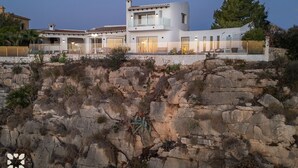 A modern house with a balcony, situated on a rocky cliff. - Villa LIGHTHOUSE by Abahana Villas (Benitachell)