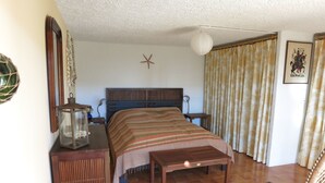 A bedroom with a bed, bedside tables, a lamp, curtains, and a starfish decoration on the wall. - Splendid sea view for this Var house 350m from the sea in a private domain. (Saint-Raphaël)
