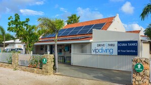 Un bâtiment avec une enseigne indiquant « Service au volant : plongée VIP » et « Réservoirs de plongée », ainsi qu’une autre enseigne indiquant « Entrée ».