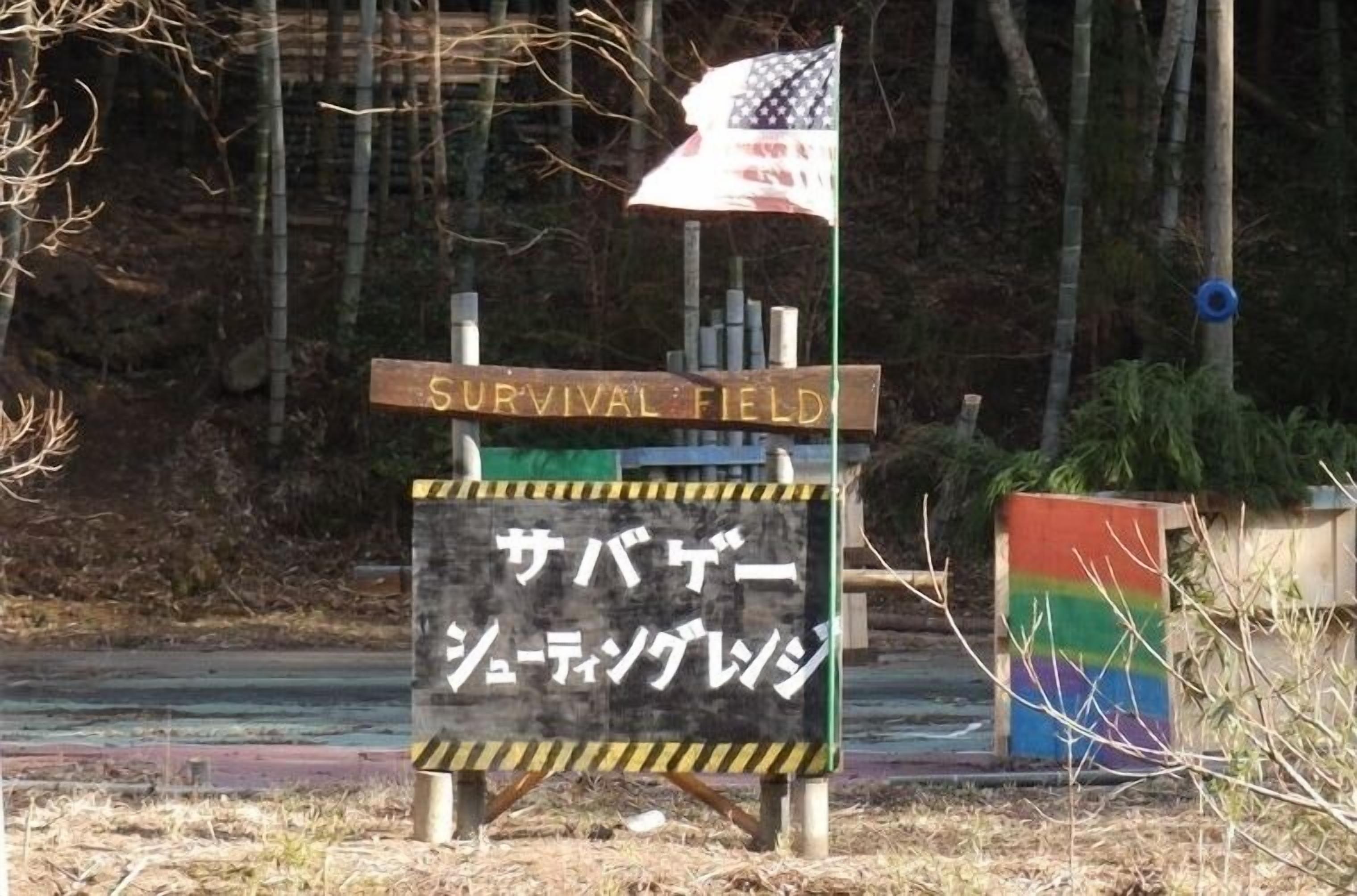 A sign with 'SURVIVAL FIELD' and Japanese text, a flag, and a rainbow-colored structure.