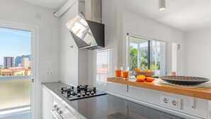 Una cocina moderna con estufa a gas, un ventanal y vistas de la ciudad.