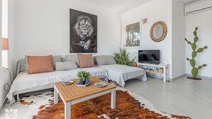 Una sala moderna con sofá, una mesa de centro y una decoración de cactus.