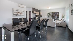Un salon moderne avec un coin repas, comprenant une grande fenêtre, un canapé et une table basse.