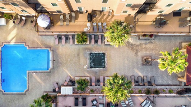 An aerial view of a rooftop pool area with a large swimming pool, sun loungers, and a hot tub. - South Beach Rental!!  212 Brass Rail Condo (tybee island)