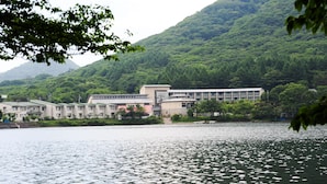 A building with multiple floors, a flat roof, and a large windowed facade. - Yusuge' Lake Haruna SPA Ryokan (Takasaki)