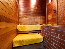 Una sauna con paredes de madera y bancos cubiertos con toallas amarillas.
