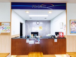 Un mostrador de recepción con un letrero que dice 'FRONT'.