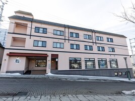 Un edificio de varios pisos con fachada plana, grandes ventanales y acceso a nivel de calle.