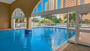 Una piscina interior con vistas despejadas a edificios circundantes y palmeras.