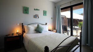 A bedroom with a bed, two bedside tables, a nightstand, a window with curtains, and a view of the outside. - A.ti.tudo Nature (Portimão)