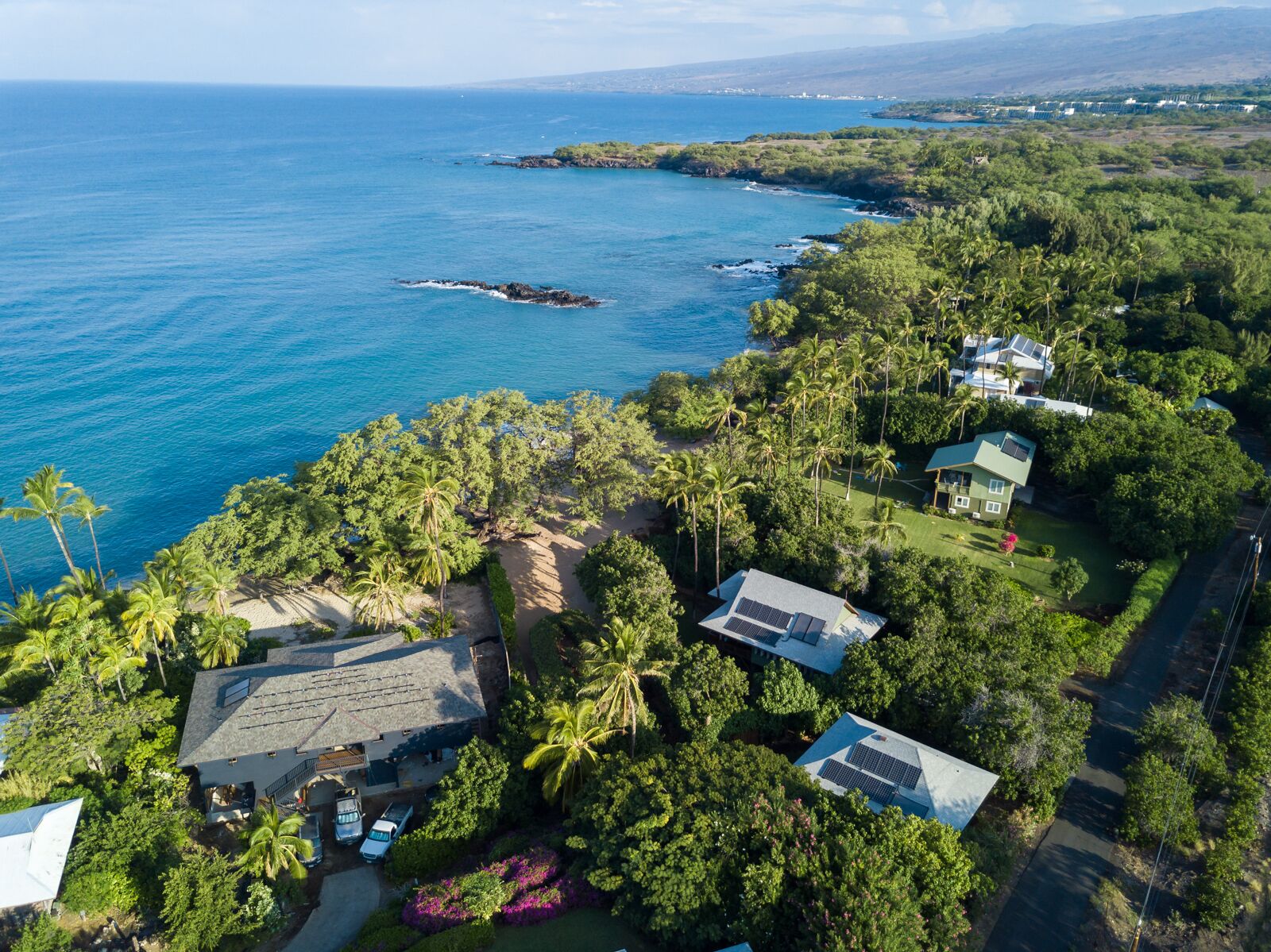 A coastal property with multiple buildings, a beach, and a view of the ocean.