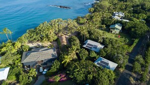 A coastal property with multiple buildings, a beach, and a view of the ocean. - Waialea Bay Beachfront Home with AC (Kamuela)