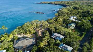 A coastal property with multiple buildings, a beach, and a view of the ocean.