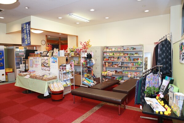 A bookstore with shelves stocked with books and magazines, a checkout counter, and a seating area with benches. - Hotel Star Land (Tsuru)