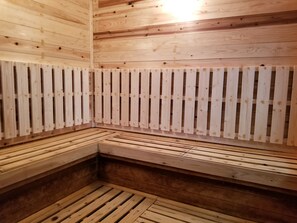 Un sauna con bancos de madera y pared de listones.