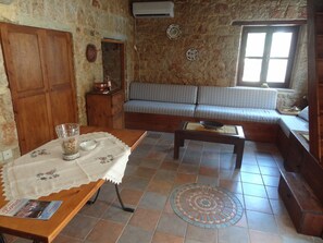 A rustic room with a wooden table, a sofa, and a patterned floor.
