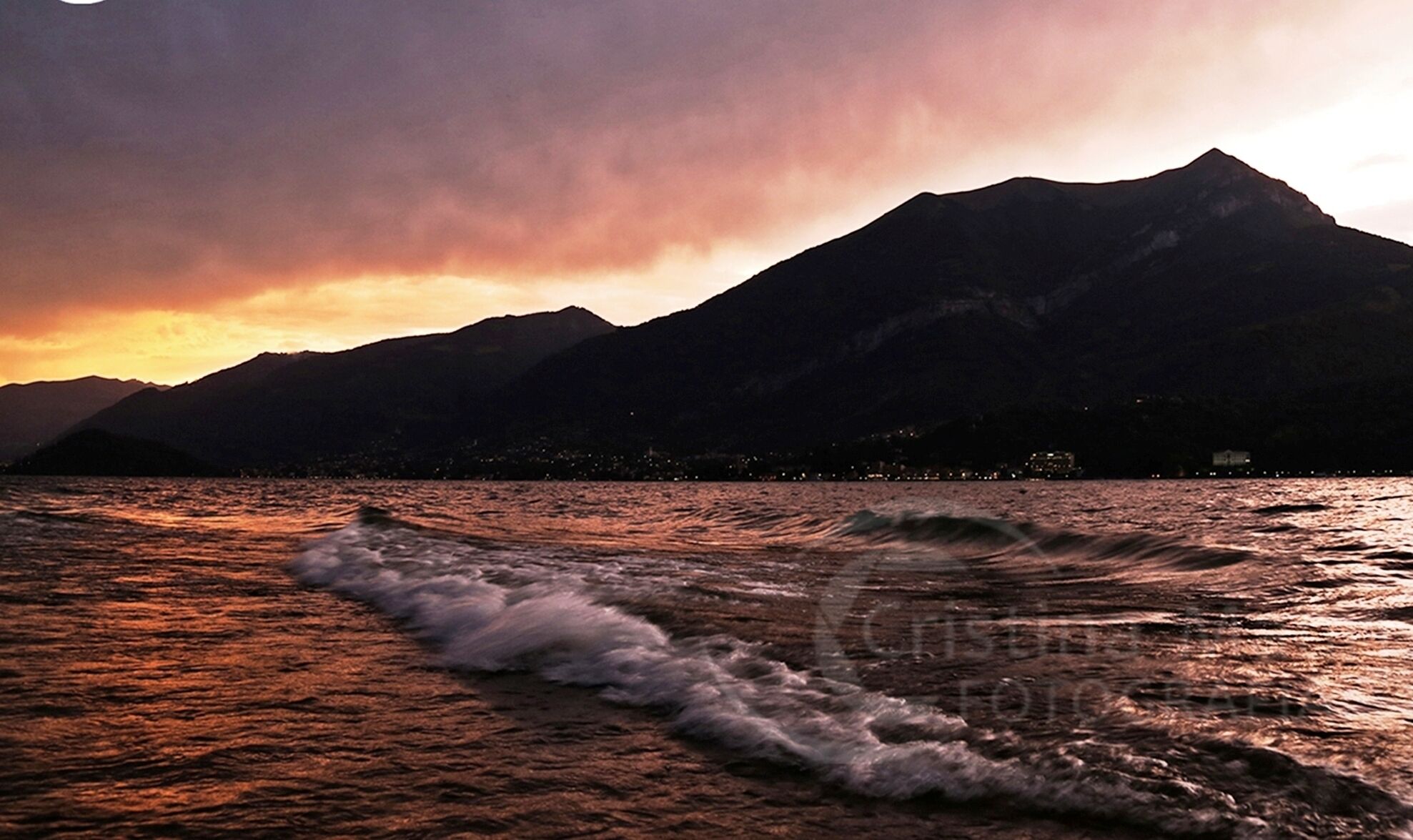 Een bergachtig landschap met een waterpartij op de voorgrond.
