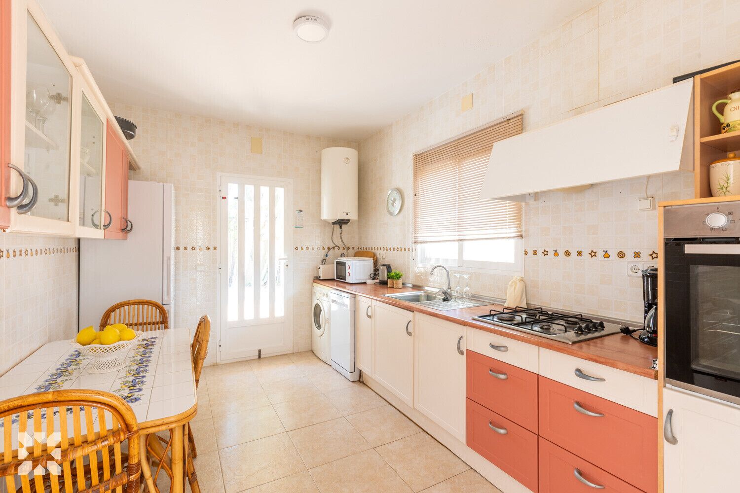 A compact kitchen with a dining area, a washing machine, a stove, and a refrigerator.