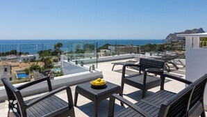 Terraza en la azotea con mobiliario exterior y vistas al mar.
