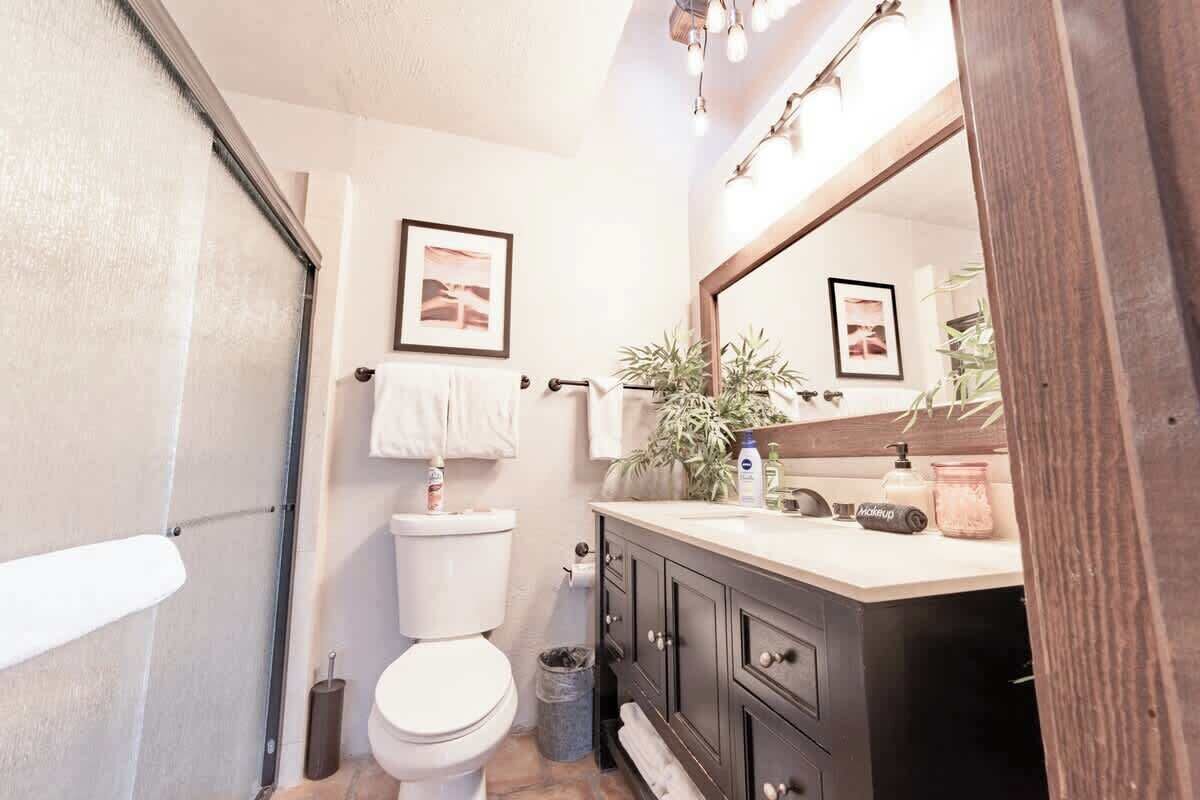 Ein Badezimmer mit Toilette, Waschbecken, Spiegel und Handtuchhalter.