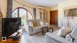 Una sala de estar con sofá, mesa de centro, televisión y chimenea.