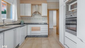 A modern kitchen with white cabinets, a stainless steel range hood, and a built-in oven. - Villa SOCRATES by Abahana Villas (Calpe)
