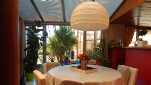 Un espace repas comprenant une table ronde, des chaises et un luminaire suspendu.