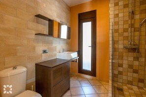 Ein Badezimmer mit Toilette, Waschbecken, Spiegel und Dusche.