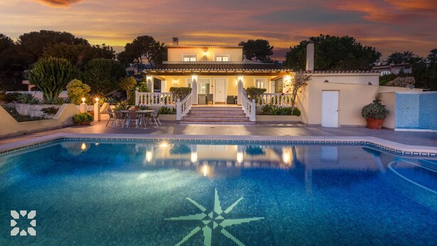 Une maison de luxe dotée d’une piscine, d’un patio couvert et d’un jardin bien entretenu.