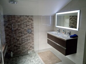 Een bad/douchecombinatie, een haardroger, een bidet, handdoeken