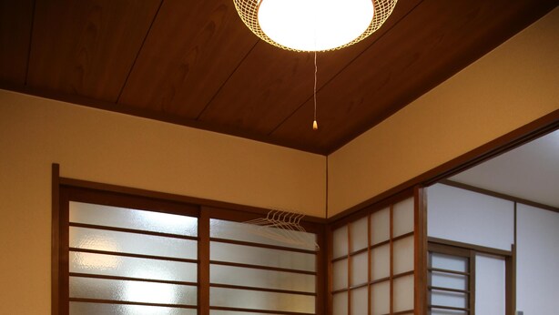 Een traditionele Japanse kamer met tatami vloerbedekking, een lage houten tafel en verschuifbare shoji deuren.