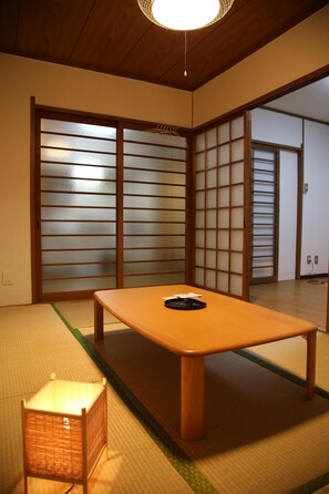 A traditional Japanese room with tatami flooring, a low wooden table, and sliding shoji doors.