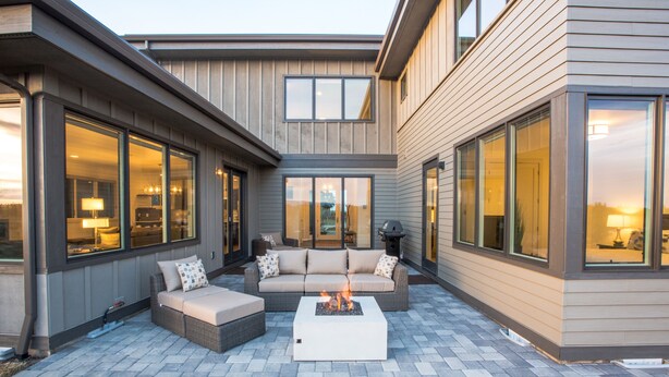 An outdoor patio area with a fire pit, seating, and large windows. - SPACIOUS ~ 24-hr staff ~ clean + modern ~ wifi ~ parking ~ hot tub ~ firepit 🐶 (Bend)